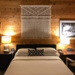 Oak king bed frame with layered bedding against a timber wall