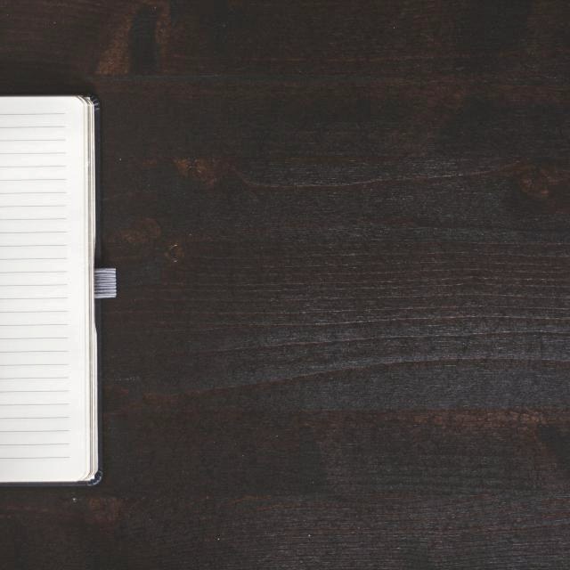 Walnut writing desk with a notebook and pen