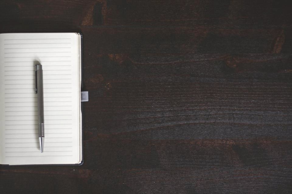 Walnut writing desk with a notebook and pen