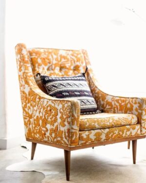Saffron wool wingback armchair beside a bright doorway